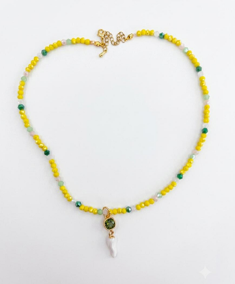 Collana con perline gialle e turchese e corno bianco con medaglione dorato