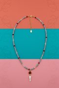 Collana grigia corno bianco su sfondo decorativo corallo turchese rosa
