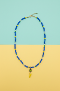 Collana blu cristalli corno giallo su sfondo turchese e giallo