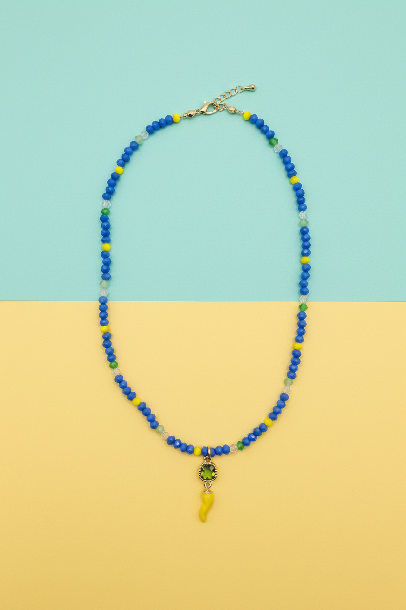 Collana blu cristalli corno giallo su sfondo turchese e giallo