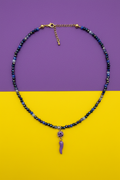 Collana blu notte corno lilla su sfondo viola e giallo