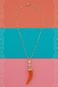 Collana corno corallo arancione su sfondo decorativo