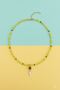 Collana gialla corno bianco su sfondo turchese e giallo